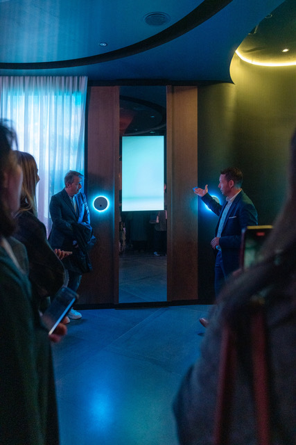 Sales representative pointing to an NFC point that activates a zone of the FLO·W showroom