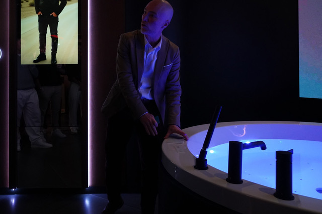 Dressing room screen with AI-generated looks next to the FLO·W bathtub